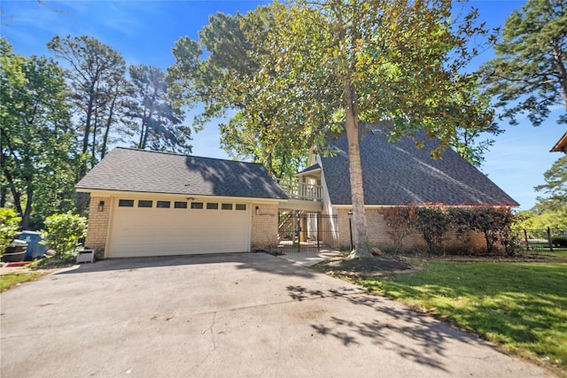 view of front of house featuring a balcony, a front yard, and a garage