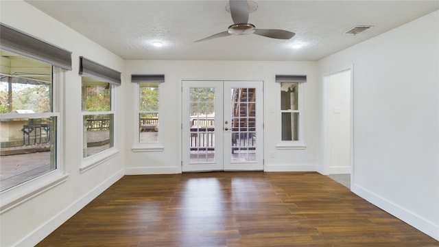 interior space with french doors, baseboards, wood finished floors, and visible vents