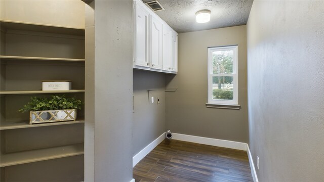 washroom featuring cabinets, a textured ceiling, dark hardwood / wood-style flooring, and washer hookup