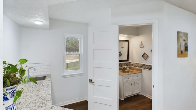 bathroom with a textured ceiling, vanity, wood-type flooring, and backsplash