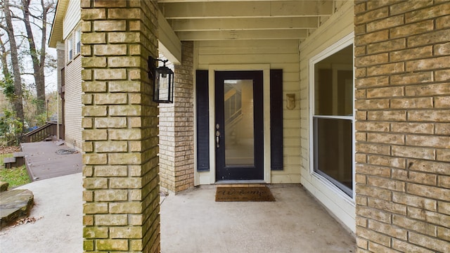 view of exterior entry with brick siding