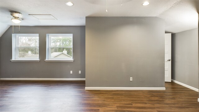 spare room with ceiling fan, dark wood-type flooring, and vaulted ceiling