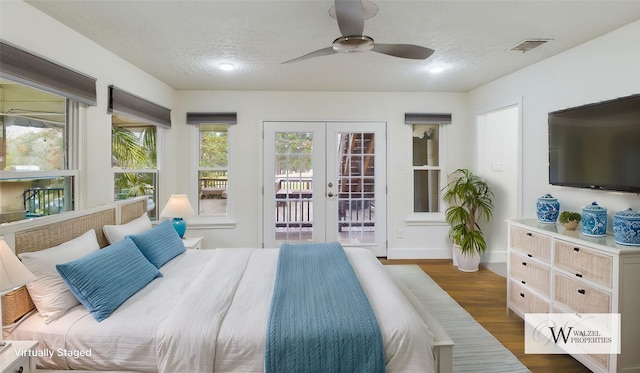 bedroom with a textured ceiling, visible vents, access to exterior, wood finished floors, and french doors