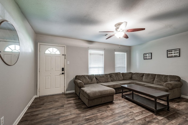 living room with dark hardwood / wood-style flooring, ceiling fan, and a healthy amount of sunlight