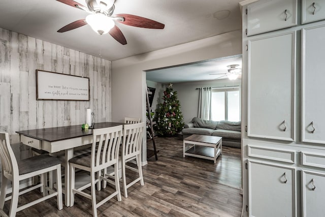 dining area with wooden walls and dark wood-type flooring