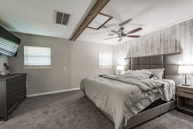 bedroom with dark colored carpet, ceiling fan, and beam ceiling