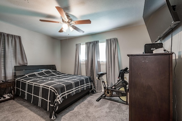 bedroom with ceiling fan, light carpet, and a textured ceiling