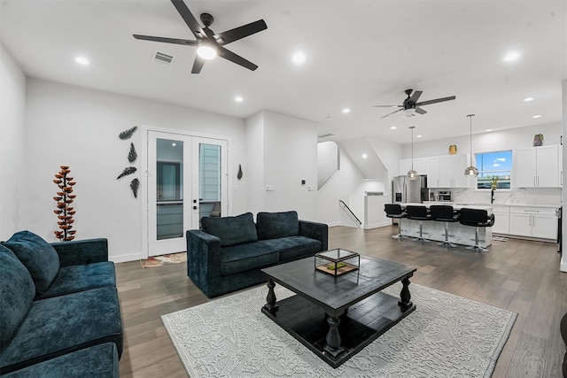 living room with hardwood / wood-style floors, french doors, ceiling fan, and sink