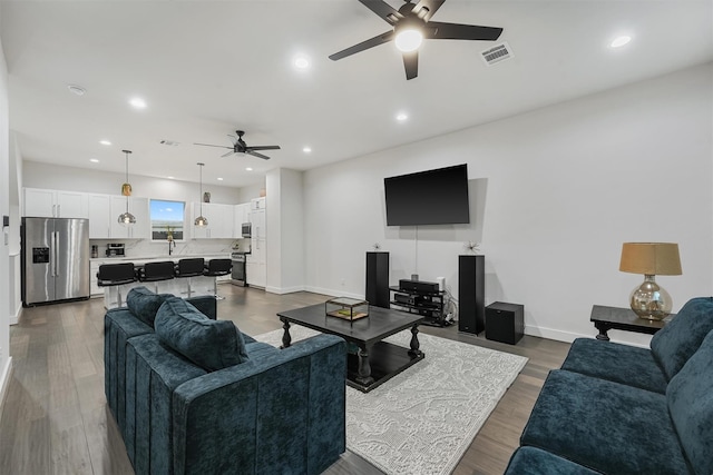 living room featuring dark hardwood / wood-style floors and ceiling fan