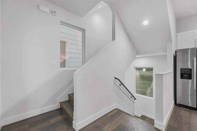 stairway featuring wood-type flooring and vaulted ceiling