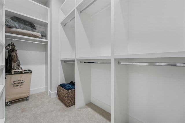 walk in closet featuring light carpet