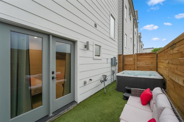 view of side of property with an outdoor living space and a hot tub