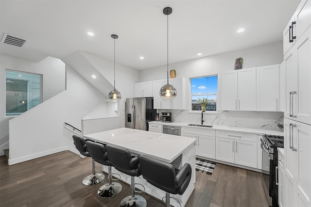 kitchen with white cabinetry, pendant lighting, stainless steel appliances, and sink