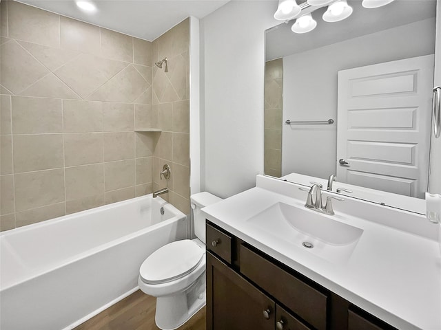 full bathroom featuring hardwood / wood-style flooring, vanity, toilet, and tiled shower / bath