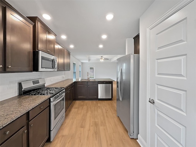 kitchen featuring sink, light hardwood / wood-style flooring, ceiling fan, tasteful backsplash, and stainless steel appliances