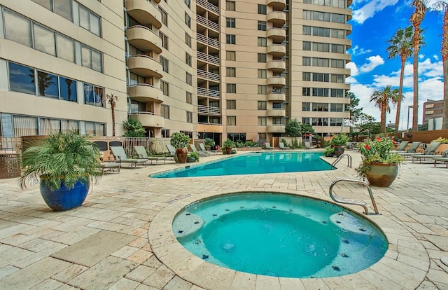 view of swimming pool featuring a patio area and a community hot tub