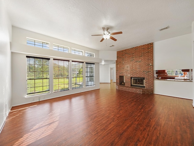 unfurnished living room with a fireplace, hardwood / wood-style floors, a textured ceiling, and ceiling fan