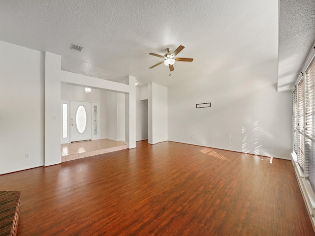 unfurnished living room featuring ceiling fan, wood-type flooring, and a textured ceiling