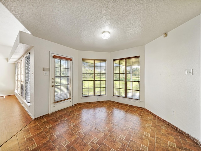 unfurnished room featuring a textured ceiling