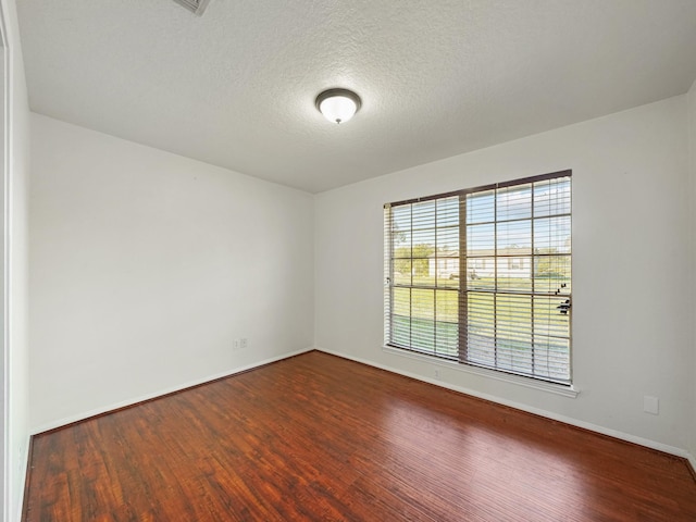 unfurnished room with hardwood / wood-style floors and a textured ceiling