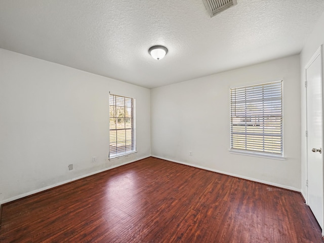 unfurnished room featuring a textured ceiling and dark hardwood / wood-style floors