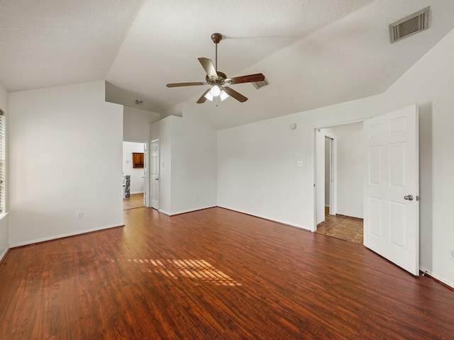 unfurnished room featuring a textured ceiling, ceiling fan, dark wood-type flooring, and lofted ceiling