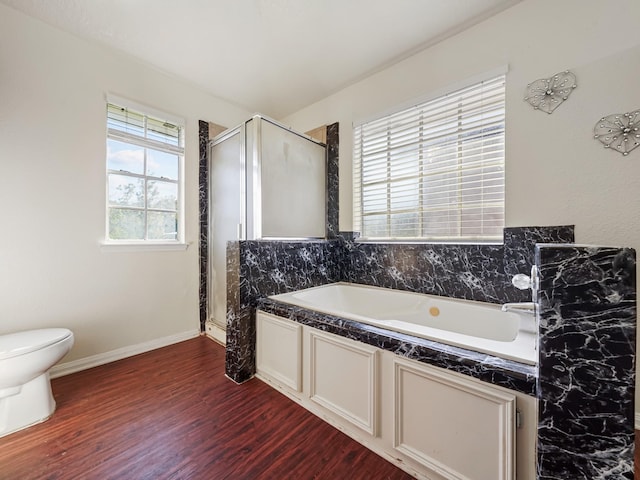 bathroom featuring shower with separate bathtub, hardwood / wood-style flooring, and toilet