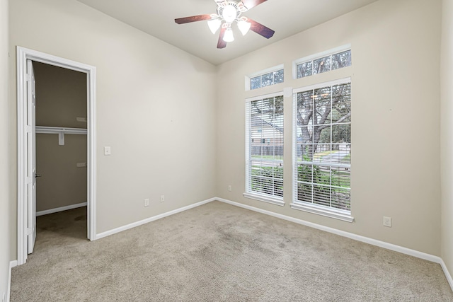 carpeted empty room featuring ceiling fan