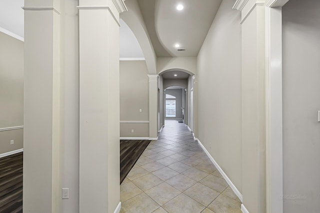 corridor featuring light tile patterned floors and crown molding