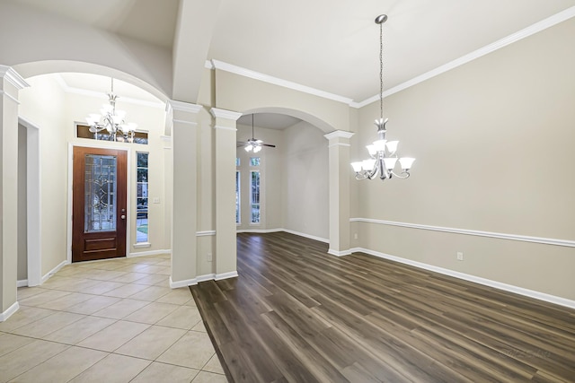 entrance foyer with ceiling fan with notable chandelier, wood-type flooring, ornamental molding, and decorative columns