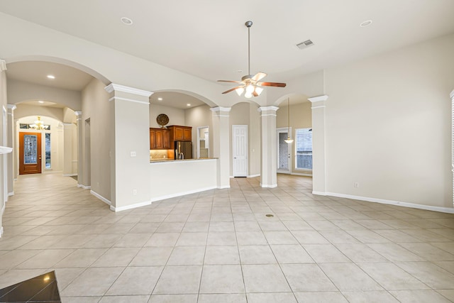 unfurnished living room with decorative columns, ceiling fan, and light tile patterned floors