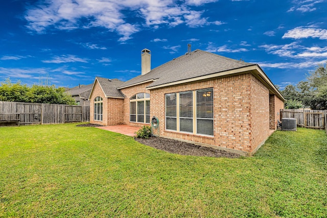 rear view of property featuring cooling unit, a yard, and a patio