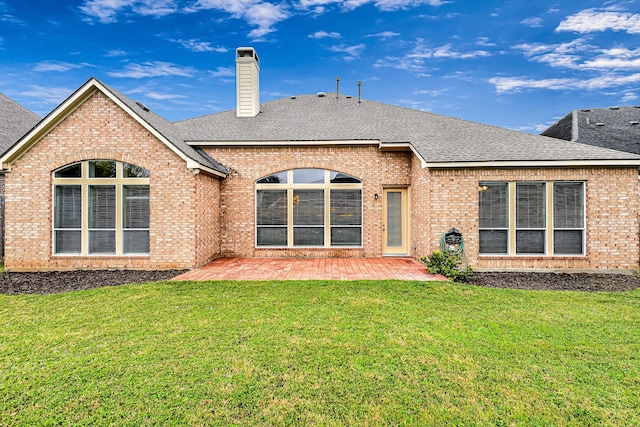 rear view of house featuring a lawn and a patio area