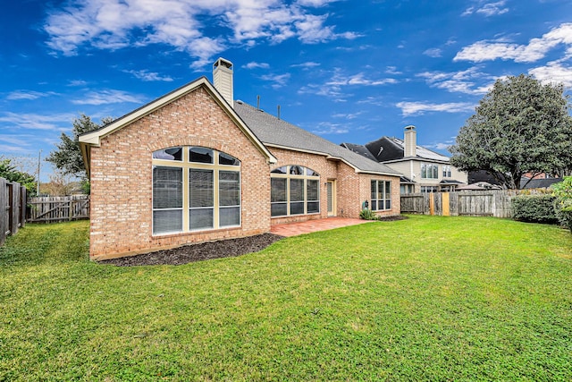 back of property with a lawn and a patio area