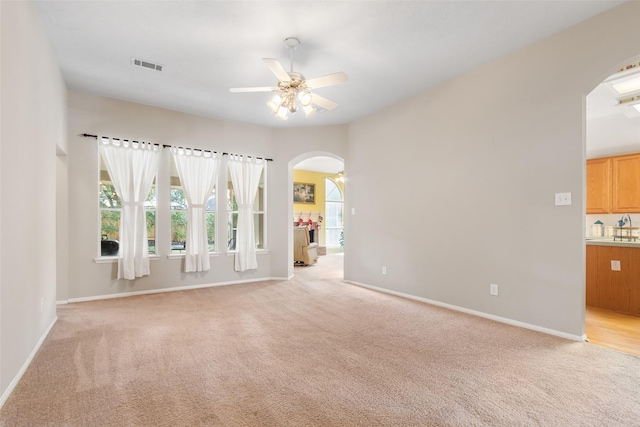 spare room featuring ceiling fan and light carpet