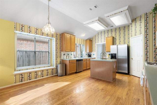 kitchen featuring light wood-type flooring, lofted ceiling, an island with sink, and stainless steel appliances