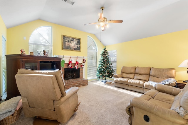 carpeted living room with ceiling fan, a fireplace, and vaulted ceiling