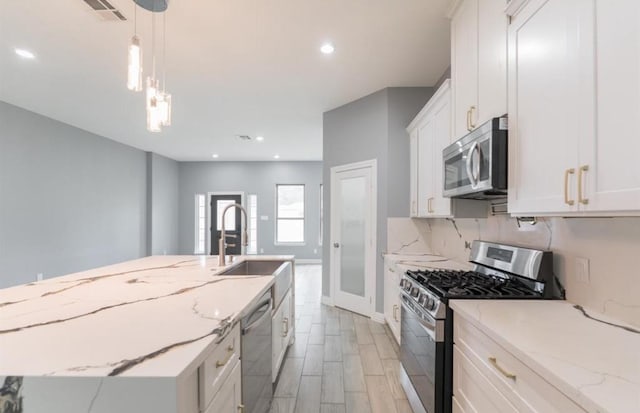 kitchen featuring white cabinetry, light stone countertops, and appliances with stainless steel finishes