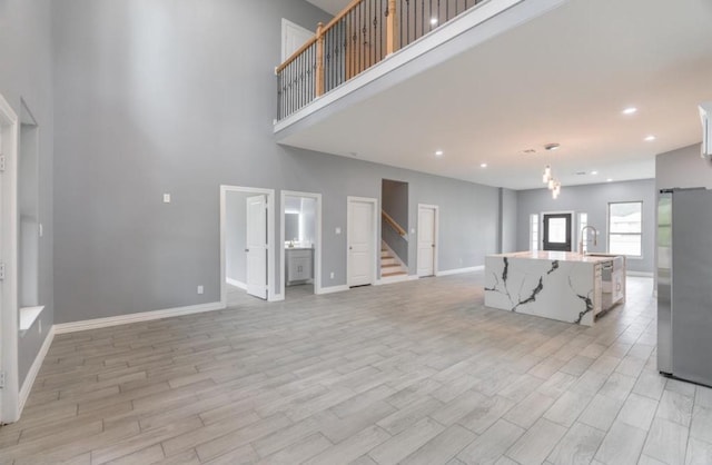 unfurnished living room with light wood-type flooring and sink