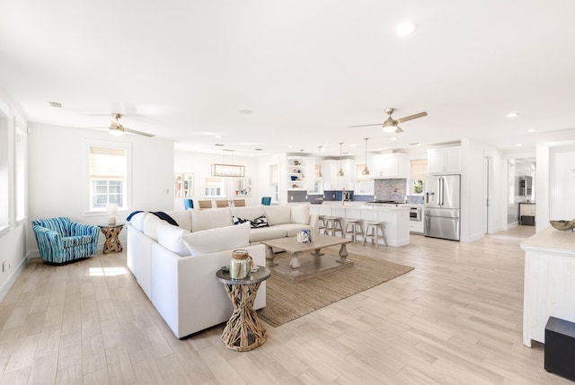 living room with visible vents, ceiling fan, light wood-style flooring, and recessed lighting