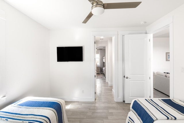 bedroom featuring baseboards, light wood-style floors, and a ceiling fan