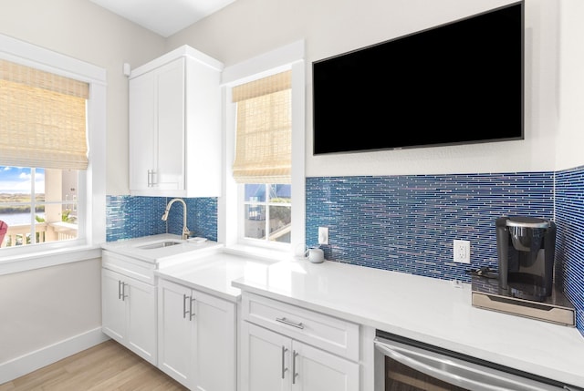 kitchen with plenty of natural light, white cabinetry, and a sink