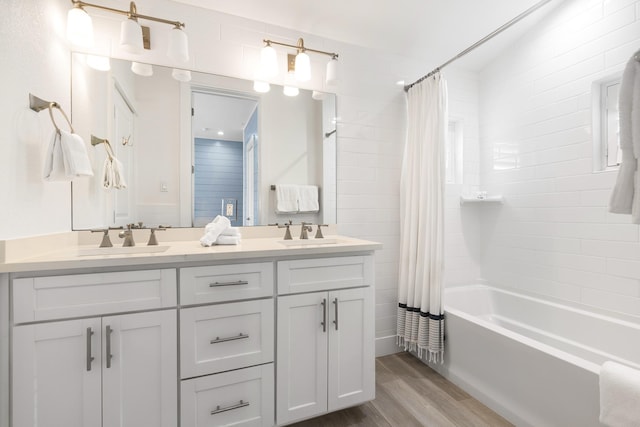 bathroom featuring hardwood / wood-style flooring, vanity, and shower / bathtub combination with curtain