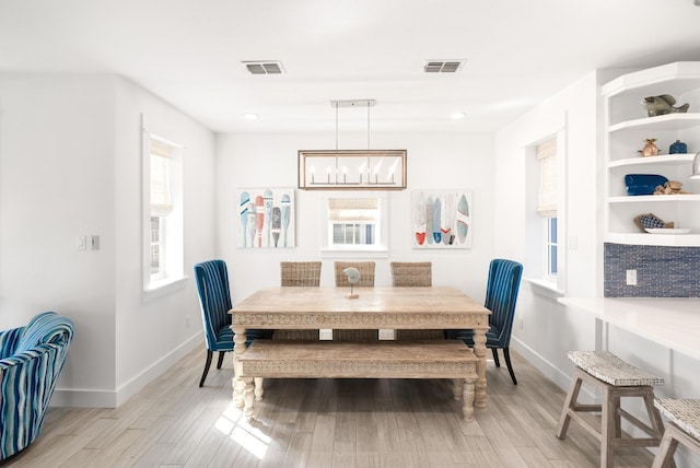 dining area featuring a chandelier and light hardwood / wood-style flooring