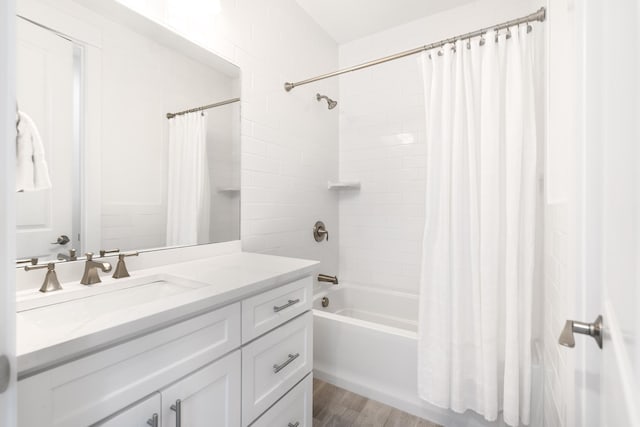 full bathroom with wood finished floors, vanity, and shower / bath combo with shower curtain