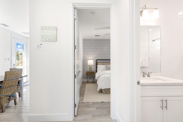 bathroom with hardwood / wood-style flooring, vanity, and a shower