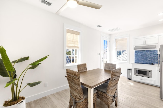 dining area with light hardwood / wood-style floors and ceiling fan