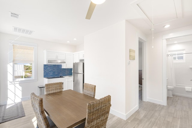 dining space with attic access, baseboards, visible vents, and light wood-style floors