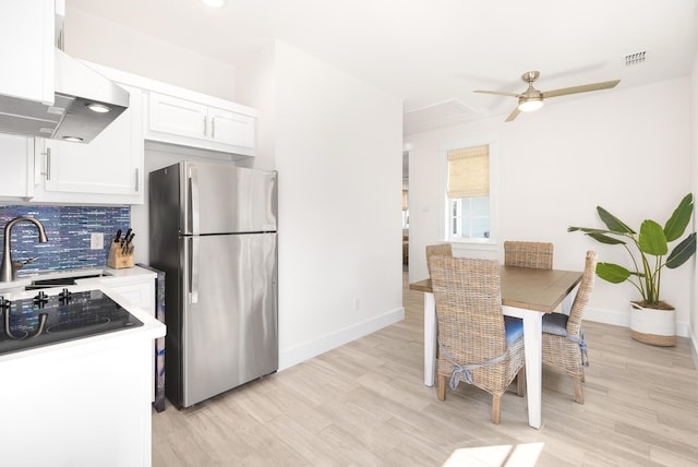 kitchen with visible vents, ceiling fan, white cabinetry, ventilation hood, and freestanding refrigerator