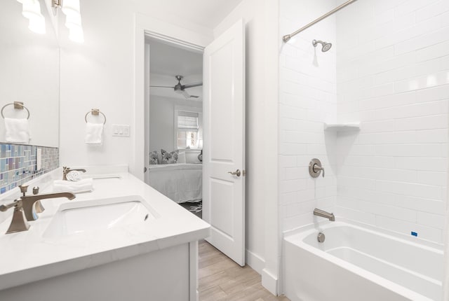 full bathroom with a sink, shower / bathing tub combination, wood finished floors, ensuite bath, and double vanity